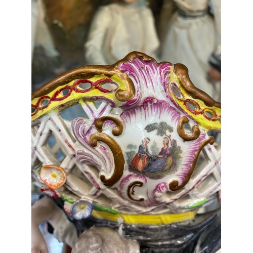 85 - A Meissen style continental figure group of a woman and child, the woman's arms supporting a pierced... 