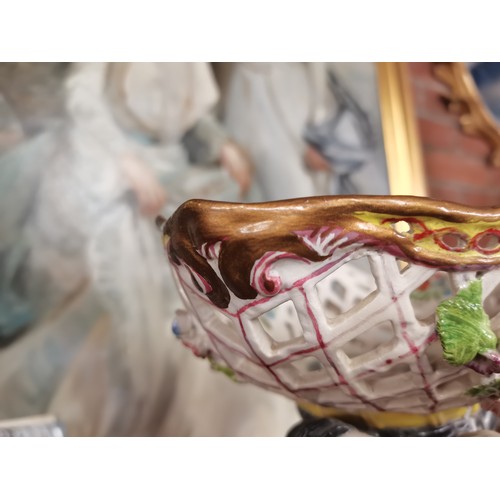 85 - A Meissen style continental figure group of a woman and child, the woman's arms supporting a pierced... 