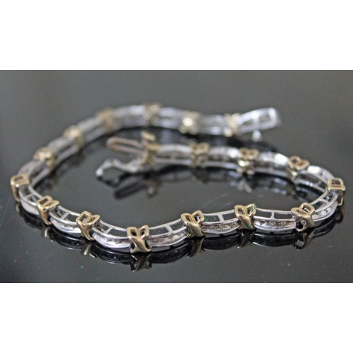 121 - A hallmarked 9ct white & yellow gold diamond bracelet, length 19cm, gross wt. 8.6g.