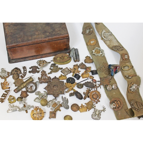 133 - A wooden box of militaria including a WWI star awarded to 3710 PTE H Brooks Manch R, cap badges vari... 