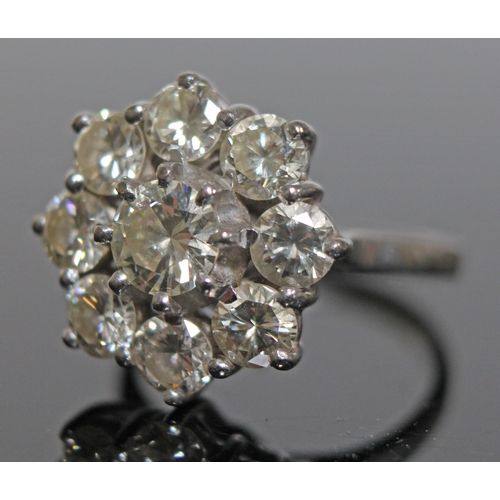 138 - A diamond round cluster ring, the central round brilliant cut and bezel set stone approx. 0.50 carat... 