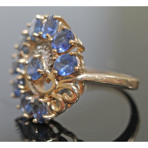 148 - A sapphire and diamond ring, 10 oval cut stones wt. approx. 2.50 carats, surrounding a diamond chip ... 