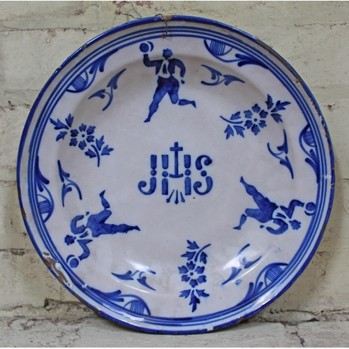 346 - An  18th/19th Century tin glazed earthenware charger decorated in blue and white with floral designs... 