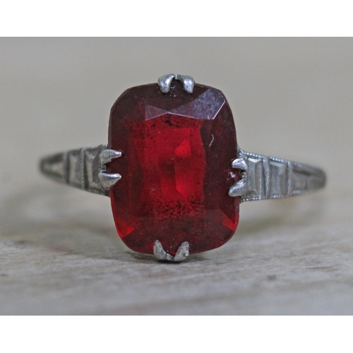 403 - A yellow metal ring set with a red stone, marked '9ct & sil', gross wt. 2.2g, size N.