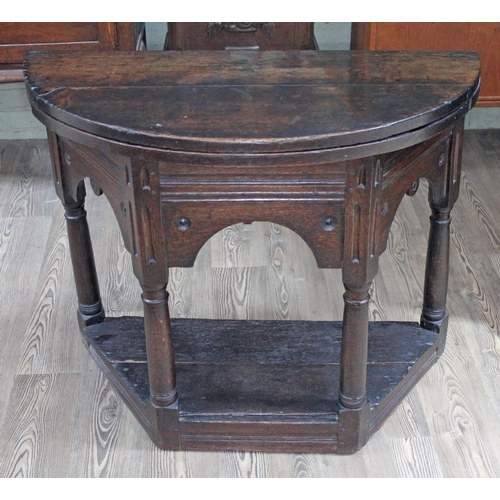 78 - A 17th Century oak credence table with demi lune fold over top above canted base with arched frieze,... 