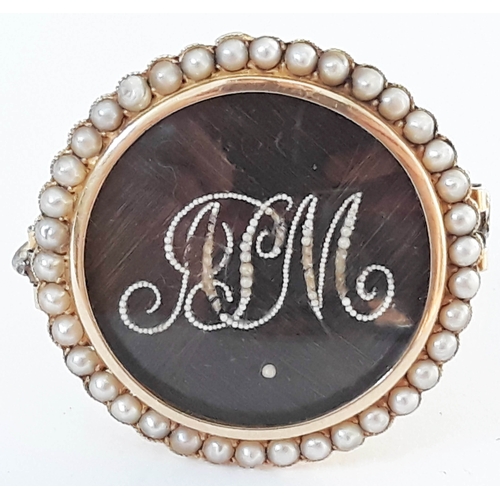 107 - A Victorian gold mourning brooch of circular form with plaited hair monogrammed RM with seed pearls ... 