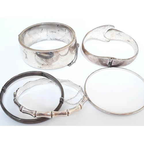 115 - A group lot of five silver bangles comprising four hallmarked silver and one marked sterling silver ... 