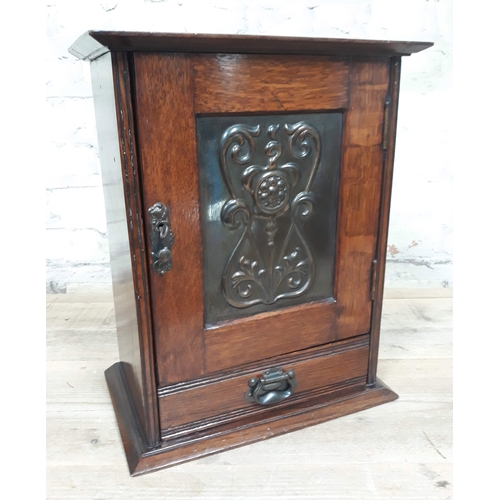 61 - An oak smoker's cabinet with Art Nouveau copper panel, height 39cm.