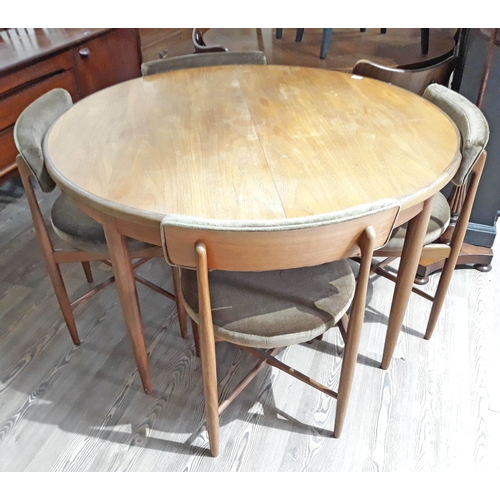 A mid 20th century G-Plan teak round extending dining table and 