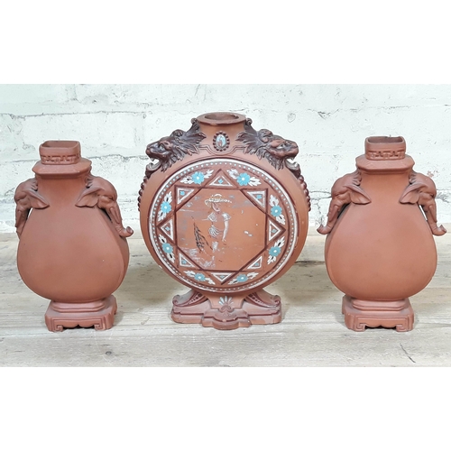 391 - A Watcombe pottery moonflask and pair of vases in the manner of Christopher Dresser.