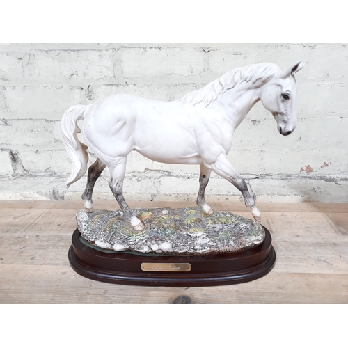 395 - A Royal Doulton Desert Orchid figure on wooden base, height 32cm.