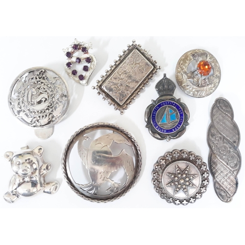 121 - A group of nine hallmarked silver and white metal brooches, gross weight 94.8g.