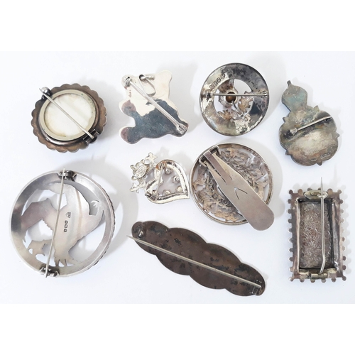 121 - A group of nine hallmarked silver and white metal brooches, gross weight 94.8g.