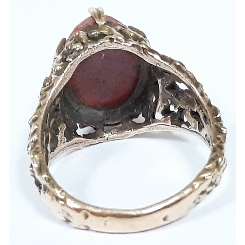 129 - A hallmarked 9ct gold ring set with a coral cabochon, gross wt. 5.7g, size N.