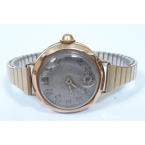 138 - A ladies 9ct gold wristwatch with gold plated sprung strap.