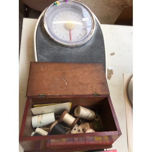 1055 - A wooden box containing some haberdashery items and a weighing scale