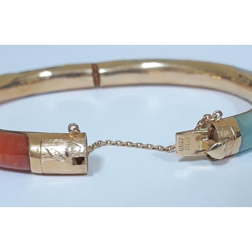 194 - A Chinese 14K multi-coloured jade bangle, marked '14K' & 585', diam. 7cm, wt. 27g.