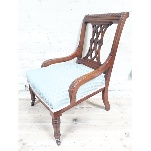 83 - A late Victorian nursing chair with acanthus carved arms and striped blue/cream upholstered seat.