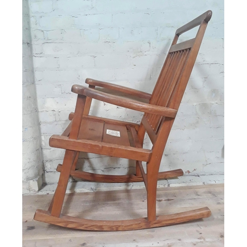 91A - A Scottish Arts & Crafts elm rocking chair, labelled 'Caithness Chairs Hand Made in Thurso'.