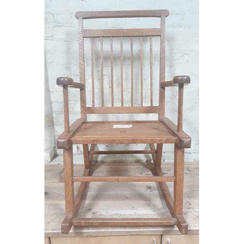 91A - A Scottish Arts & Crafts elm rocking chair, labelled 'Caithness Chairs Hand Made in Thurso'.