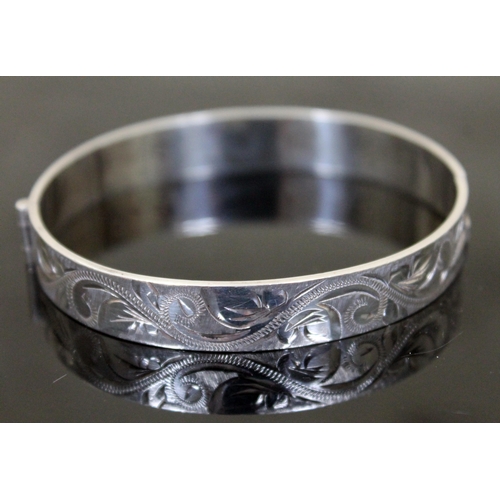 146 - A hallmarked silver hinge bangle with engraved decoration to outer edge, diameter 6.5cm, gross weigh... 