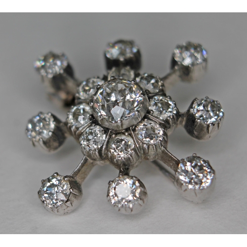 156 - A diamond star cluster brooch, crafted in white metal, unmarked, the central old cut diamond approx.... 