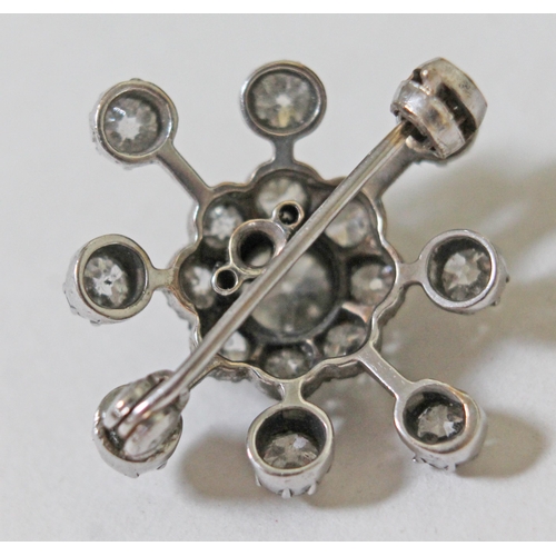 156 - A diamond star cluster brooch, crafted in white metal, unmarked, the central old cut diamond approx.... 