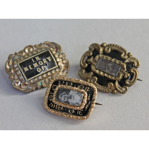 242 - A group of three William IV/early Victorian yellow metal and black enamel mourning brooches.