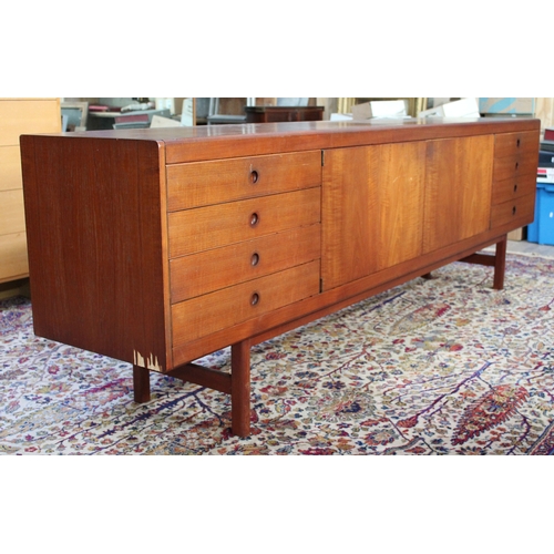 75 - A 1960s 8' teak sideboard having eight drawers either split either side of a central cabinet, length... 