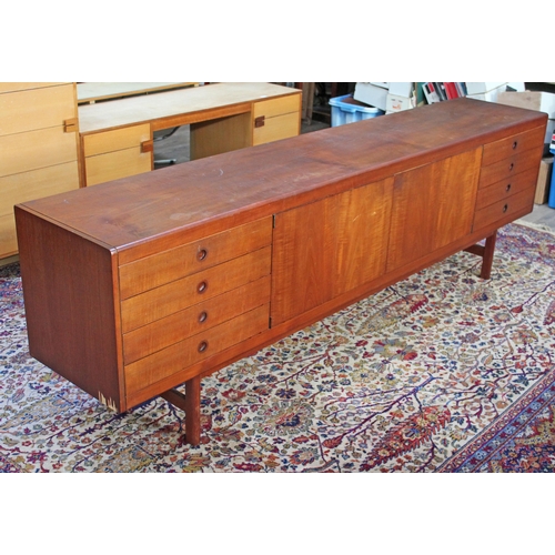 75 - A 1960s 8' teak sideboard having eight drawers either split either side of a central cabinet, length... 