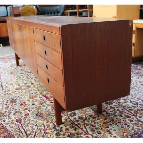 75 - A 1960s 8' teak sideboard having eight drawers either split either side of a central cabinet, length... 