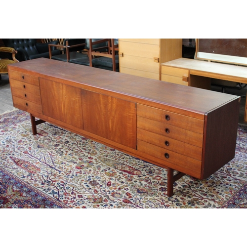 75 - A 1960s 8' teak sideboard having eight drawers either split either side of a central cabinet, length... 