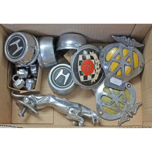 293 - A box including car badges, a Jaguar mascot, wheel nuts etc.