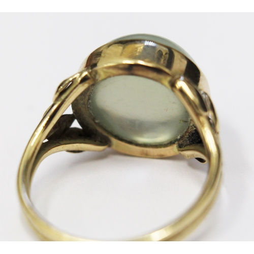 117 - A moonstone cabachon ring, the stone in bezel setting with tulip shoulders, unmarked, size N/O, gros... 