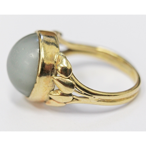 117 - A moonstone cabachon ring, the stone in bezel setting with tulip shoulders, unmarked, size N/O, gros... 