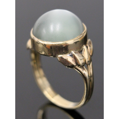 117 - A moonstone cabachon ring, the stone in bezel setting with tulip shoulders, unmarked, size N/O, gros... 