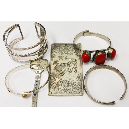 139 - A mixed lot to include four silver bangles, a Bulova wristwatch and an eastern ingot.