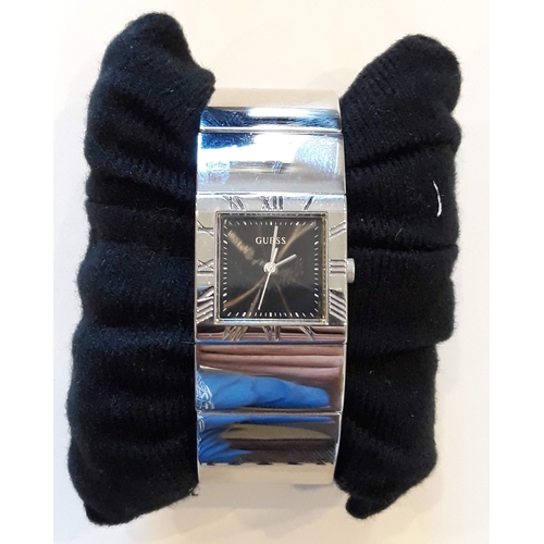 173 - A ladies Guess stainless steel bangle wristwatch.