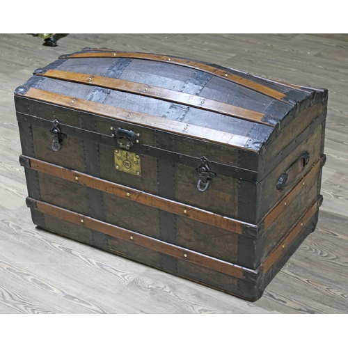 61 - A 19th Century wooden metal and leather bound domed trunk with leather carry handles.