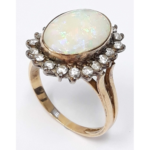 100I - An opal cabochon and diamond ring, the central cabochon 9mm x 14mm, hallmarked 14ct gold band, gross... 