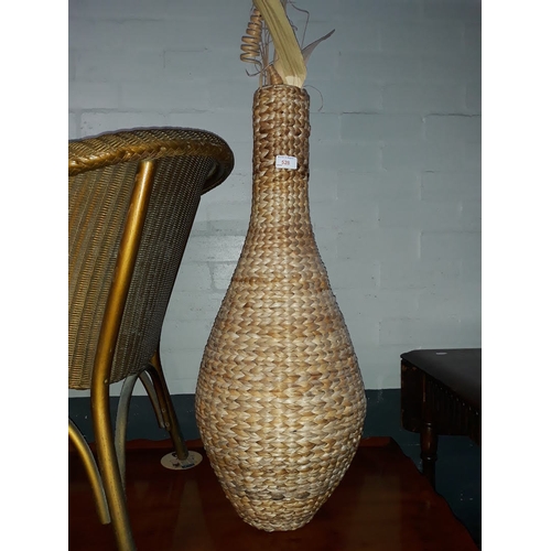 528 - A woven vase with dried flowers, height 80cm.