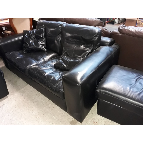 669 - A black leather settee and pouffe.