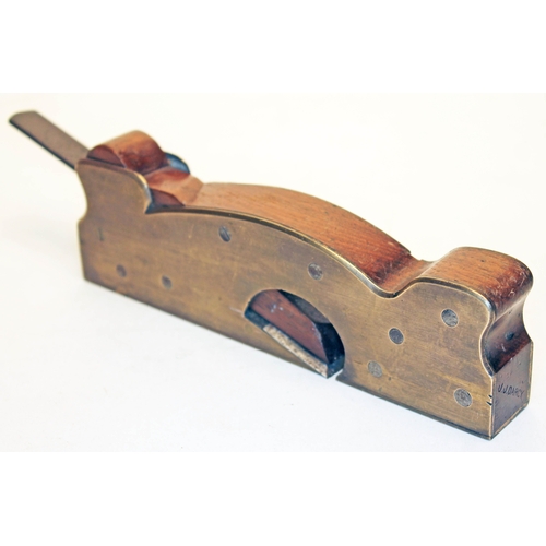 253 - A 19th century brass rebate plane of shaped form, mahogany infill and steel blade inscribed 'Alex Ma... 