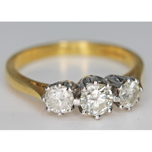 223 - A three stone diamond ring, total approx. diamond wt. 0.75 carats, hallmarked 18ct gold band, gross ... 