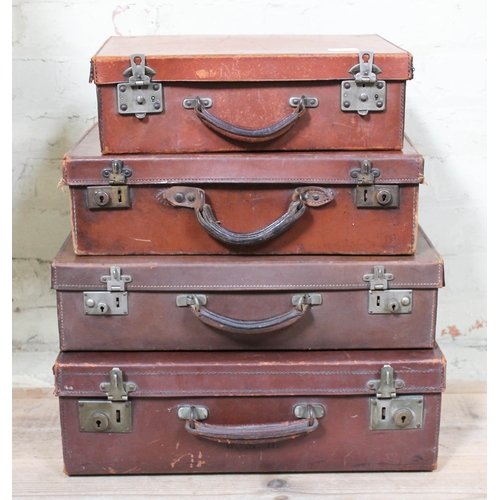 395 - A stack of four vintage leather travel cases.