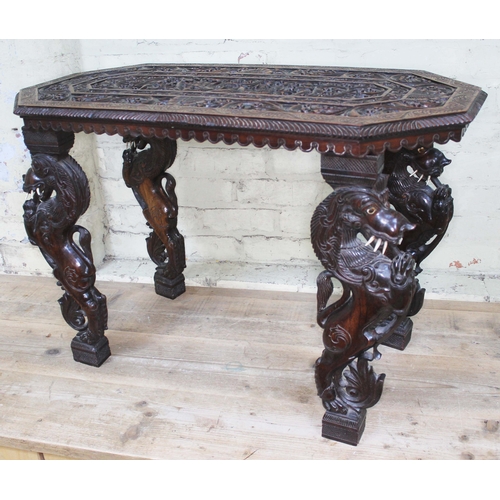 68 - A profusely carved Indian table, height 60cm.