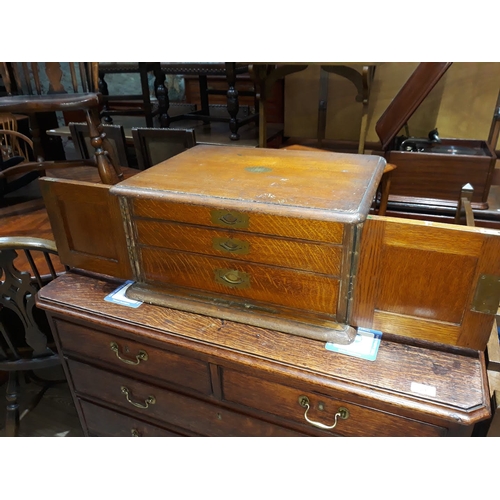 90C - An oak canteen of cutlery, two panelled doors opening to reveal three drawers of various silver plat... 