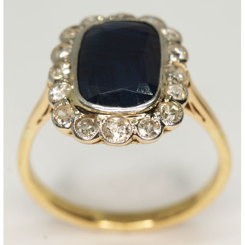 102 - A sapphire and diamond ring, the central rectangular cut stone approx. 5.43ct, the surrounding stone... 