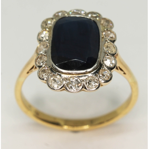 102 - A sapphire and diamond ring, the central rectangular cut stone approx. 5.43ct, the surrounding stone... 
