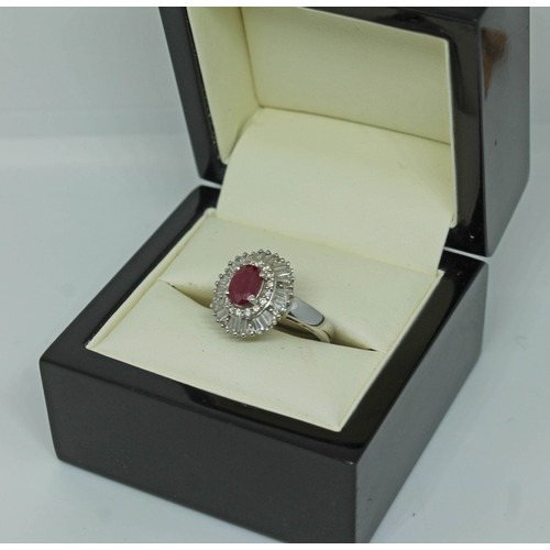 170 - A contemporary Art Deco style ruby and diamond cluster ring, the oval cut ruby set within a surround... 